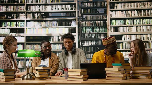 Students talking in a library with vast bookshelves