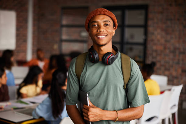 Student in headphones smiling in a campus common area