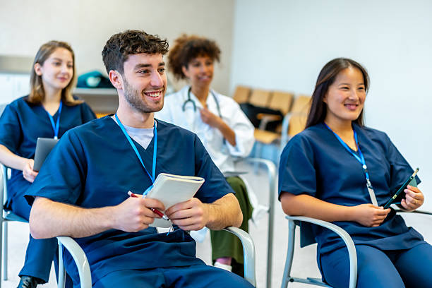 Nursing students in scrubs sitting in a lecture hall