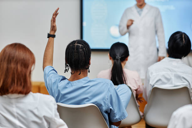 Student raising a hand in a lecture